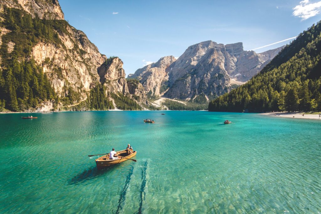 Three wooden boats on a clear blue lake